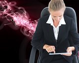 Businesswoman sitting on swivel chair with tablet