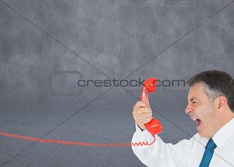Businessman screaming directly into the handset