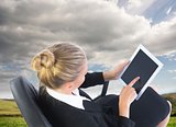 Businesswoman sitting on swivel chair with tablet