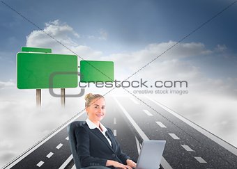 Businesswoman sitting in swivel chair with laptop