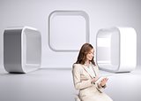 Pleased businesswoman using a tablet pc sitting on a bar chair