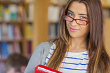 Close up portrait of a smiling female student in library