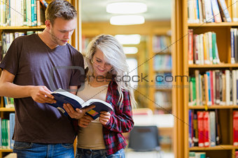 Two young students reading book in the library