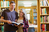 Portrait of two students reading book in the library