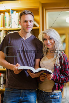 Portrait of two students reading book in the library