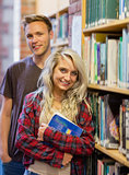 Students standing by bookshelf in the library