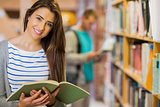 Two students by bookshelf in the library