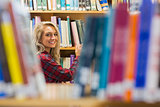 Smiling female amid bookshelves in the library