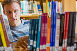 Male student selecting book in the library