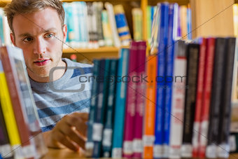 Male student selecting book in the library