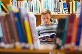 Male student reading a book in the library