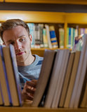 Male student selecting book in the library