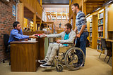 Male student in wheelchair at the library counter