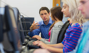 Teacher explaining to students in the computer room