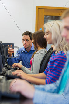 Teacher explaining to students in the computer room