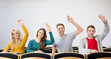 College students raising hands in the classroom
