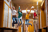 Students jumping in college corridor