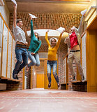 Group of students jumping in college corridor