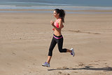 Full length of healthy woman jogging on beach