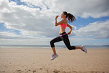 Full length of healthy woman jogging on beach