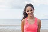 Smiling healthy with earphones on beach