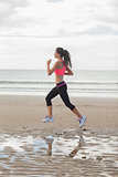Full length of a healthy woman jogging on beach