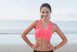 Smiling healthy woman with earphones on beach