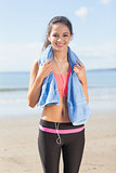Beautiful healthy woman with towel around neck on beach