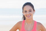 Close up of smiling healthy with earphones on beach
