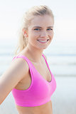Close up of healthy woman in pink sports bra on beach