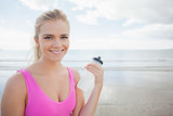 Smiling healthy woman with water bottle on beach