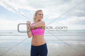 Smiling toned woman exercising on beach