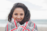 Young woman covered with blanket at beach