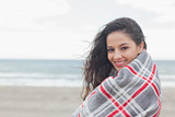 Portrait of woman covered with blanket at beach
