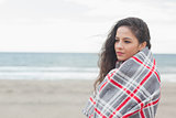 Side view of a woman covered with blanket at beach