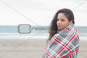 Side view of a woman covered with blanket at beach