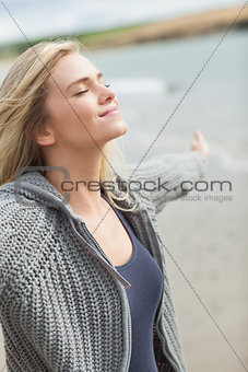 Side view of a woman stretching her arms on beach