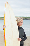 Smiling beautiful woman with surfboard on beach