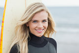 Portrait of a smiling beautiful woman with surfboard