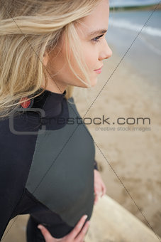 Side view of beautiful blond in wet suit at beach