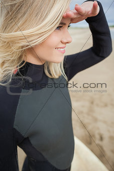 Side view of beautiful blond shielding eyes at beach