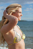 Side view of smiling beautiful bikini woman at beach