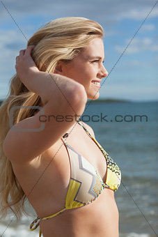 Side view of smiling beautiful bikini woman at beach