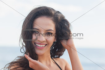 Close up portrait of cute smiling woman at beach