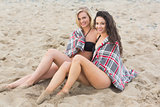 Young women covered with blanket at beach