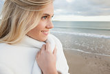 Cute smiling woman in stylish white jacket on beach