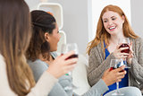 Cheerful friends with wine glasses enjoying a conversation at home