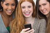 Close up portrait of cheerful friends with mobile phone
