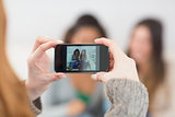 Close up of a woman photographing friends with smartphone