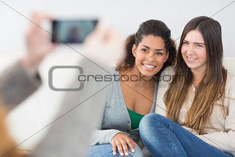 Woman photographing friends with smartphone